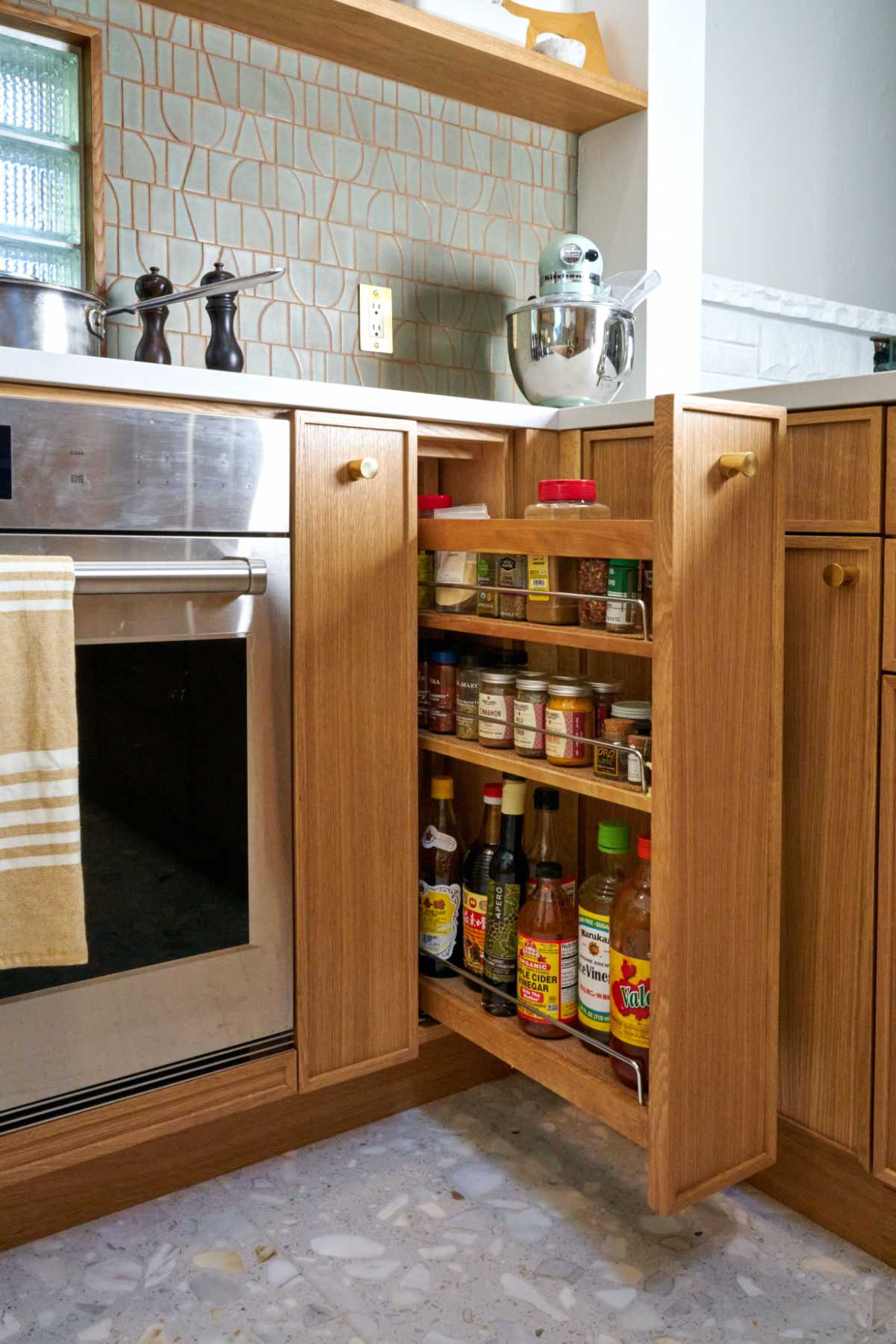 Kitchen spice rack pull out next to oven.