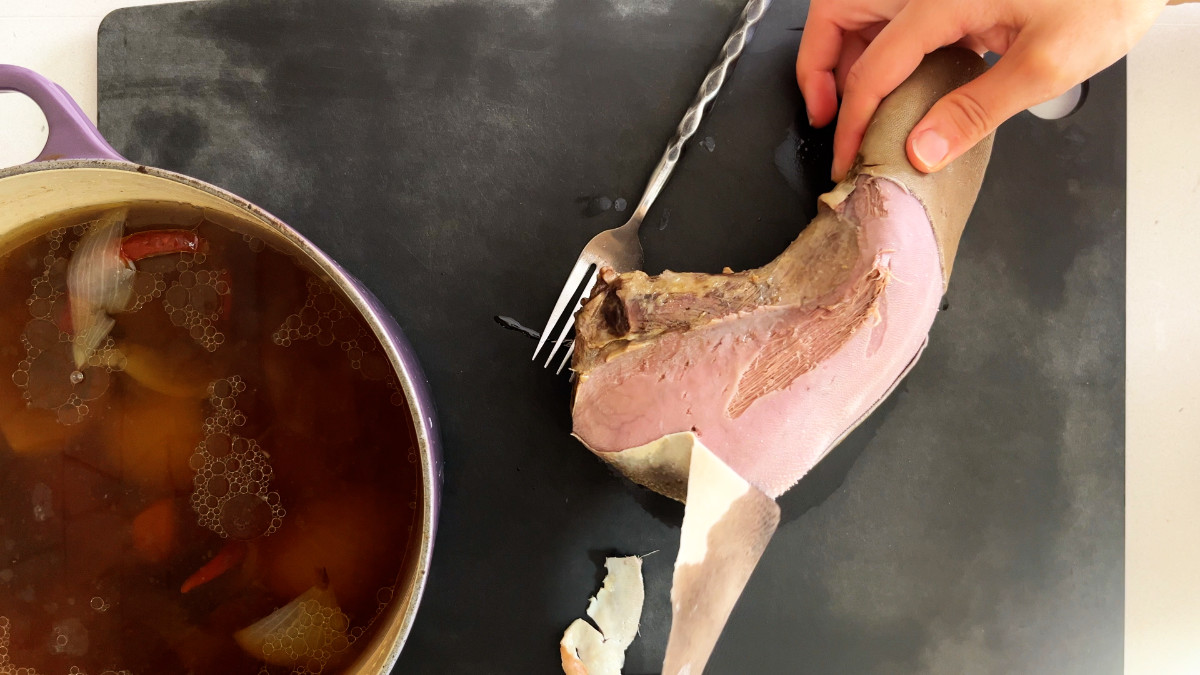 Peeling membrane off a beef tongue.