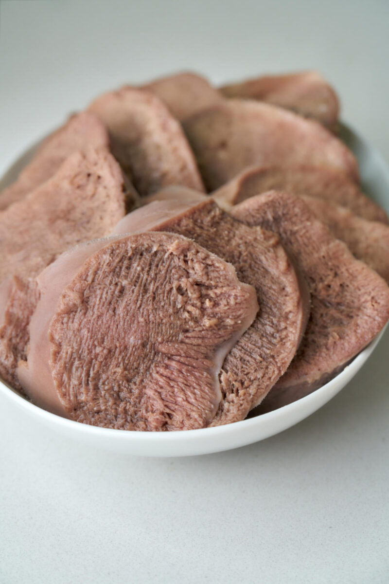 Sliced cow tongue on a plate.