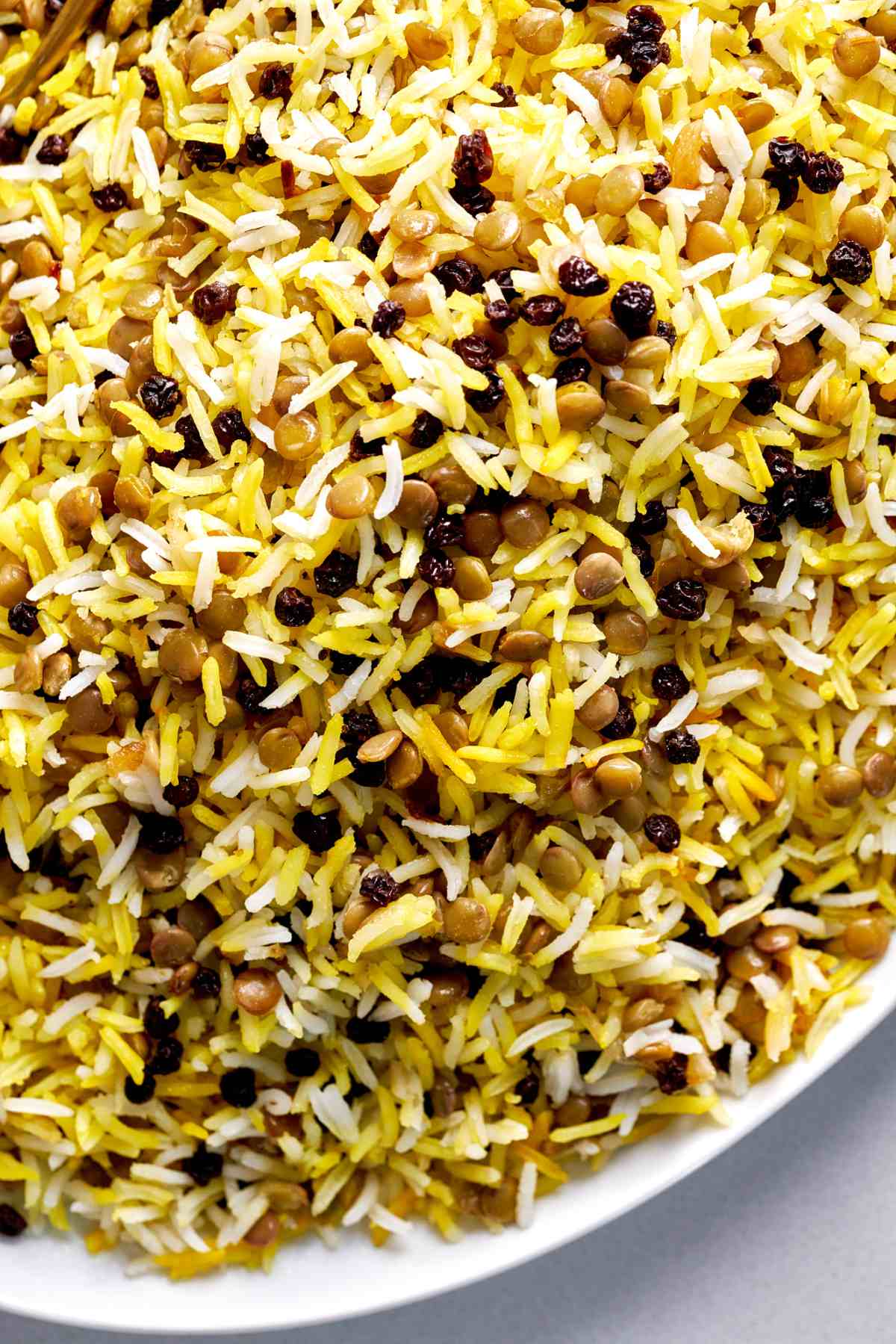 Yellow rice with lentils and currants in serving dish.