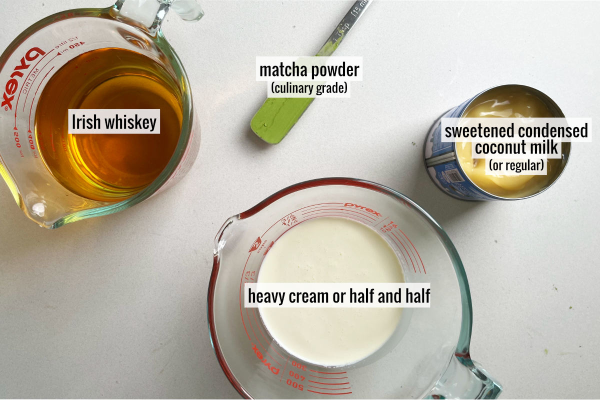 Whiskey, matcha, and other ingredients on a countertop.