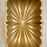 Gold fluted loaf pan on white marble.