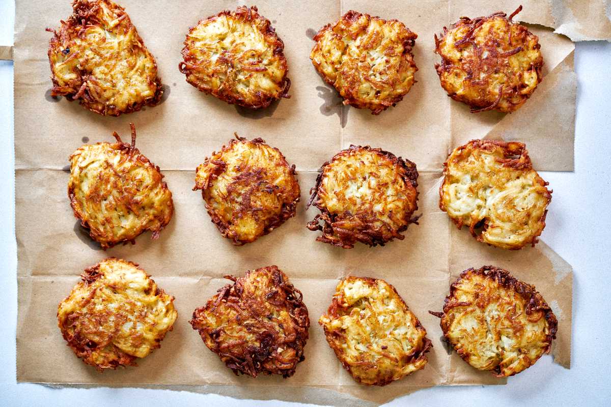 Fried potato latkes on a paper bag.