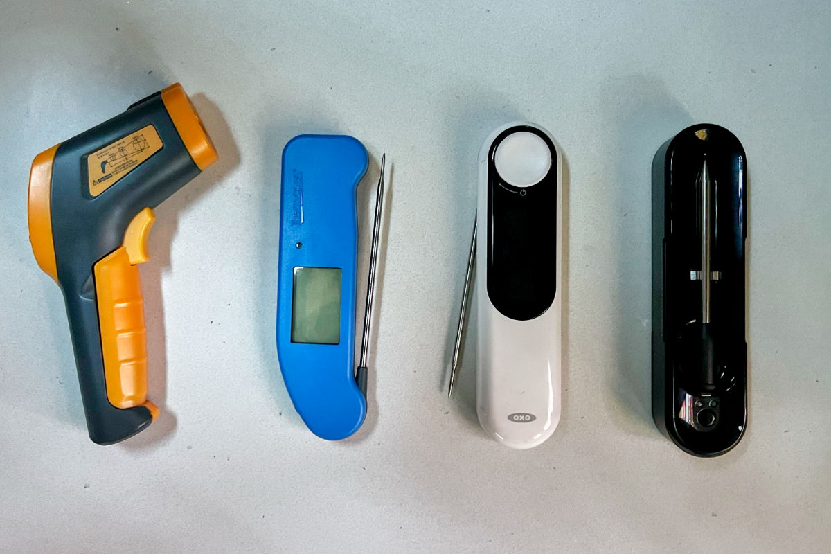 Four thermometers on a countertop.