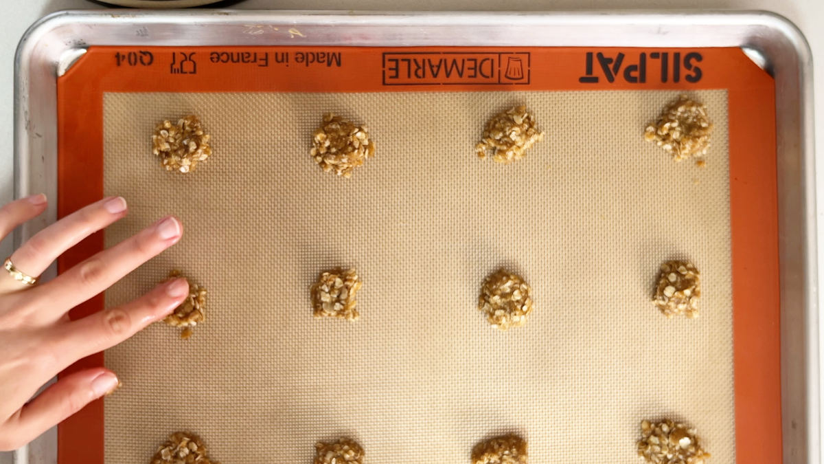 Drops of dough on a baking sheet with silicone mat.