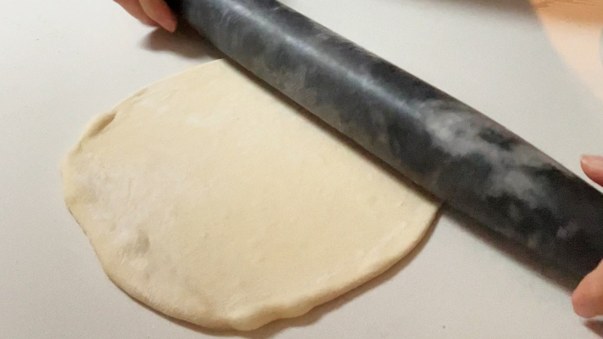 Rolling dough into a circle shape.