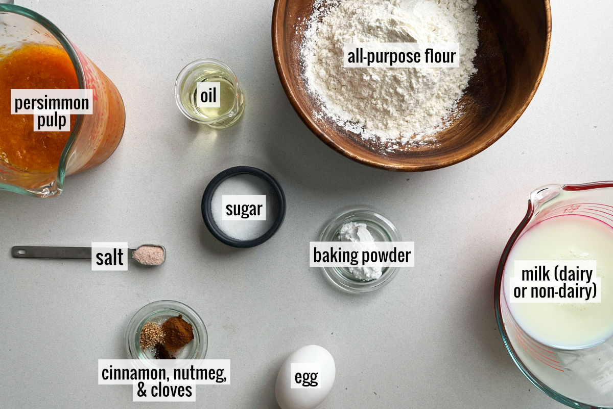 Ingredients to make pancakes like flour, persimmon, milk, sugar, egg, and spices.