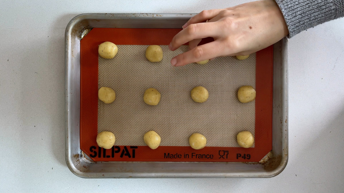 Cookie dough balls on a baking sheet.