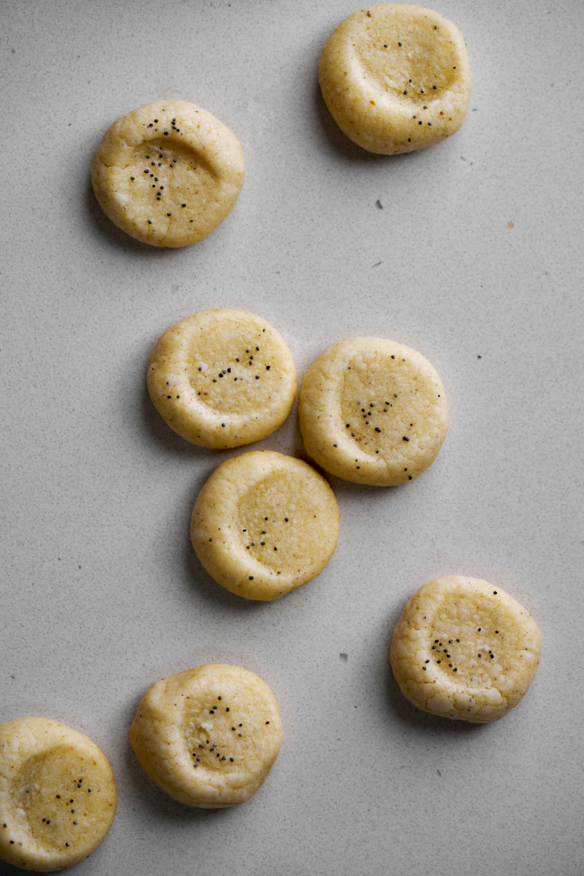 Cookies with poppyseeds on a countertop.