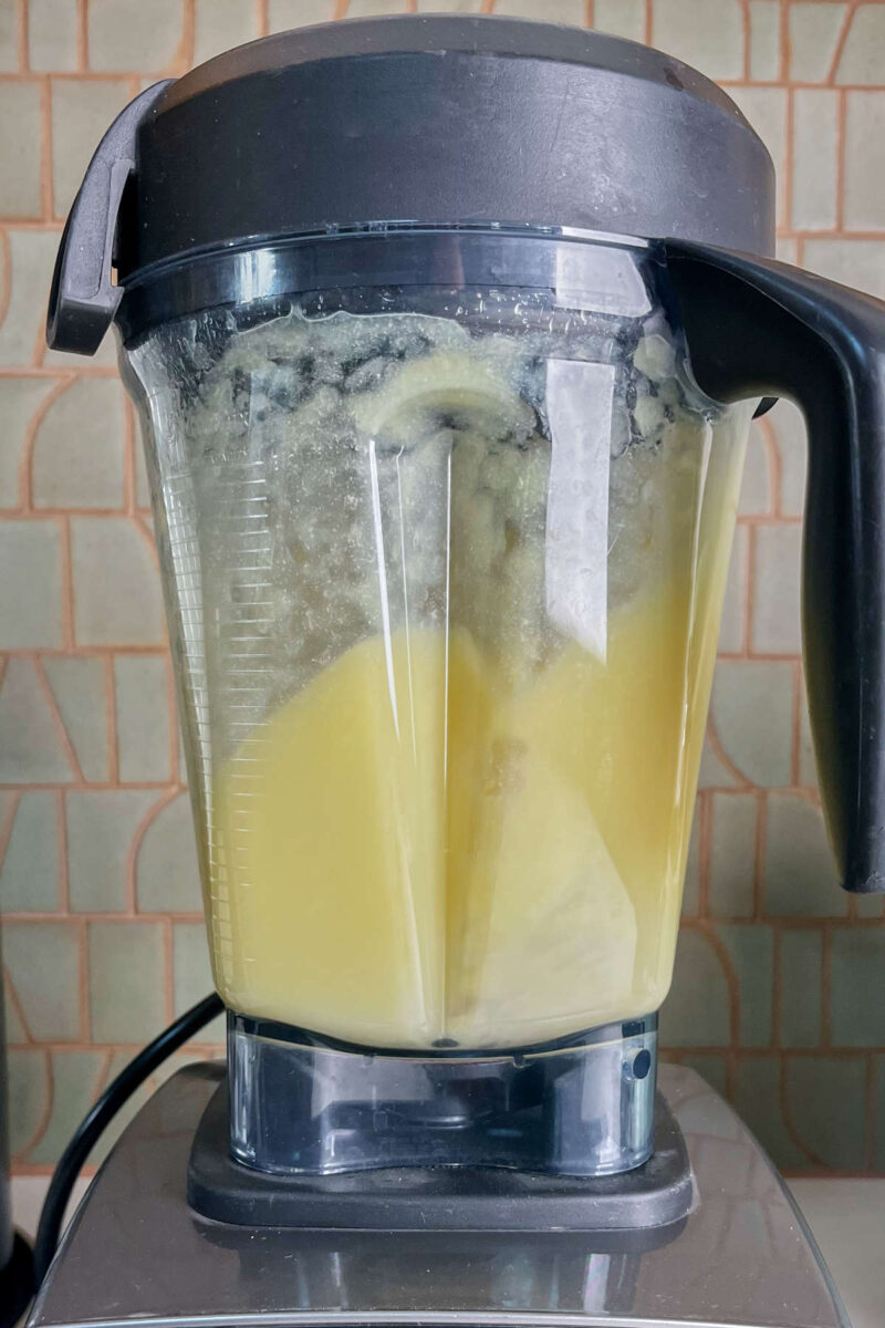 Blending Dole Whip mixture of pineapple and sweetener in a blender.
