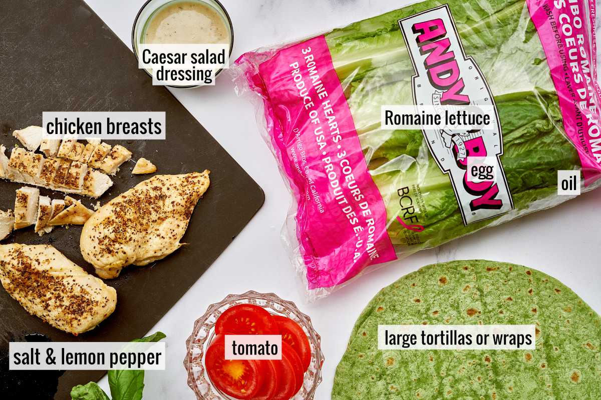 Ingredients to make caesar salad wraps like romaine lettuce in packaging and cooked chicken breasts.