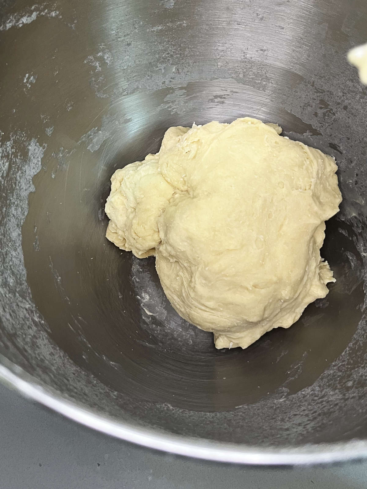 Dough in a stand mixer bowl with a whisk attachment.