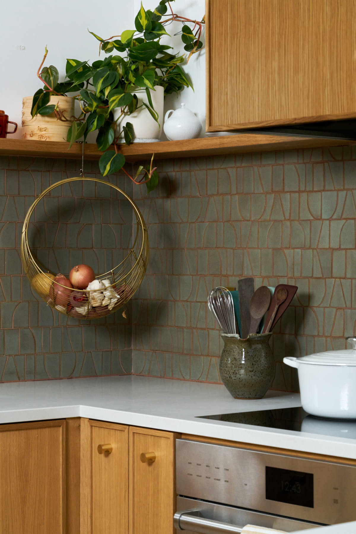 Kitchen oven and hood with wood cabinets.