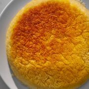 Crispy yellow tahdig on a white plate.