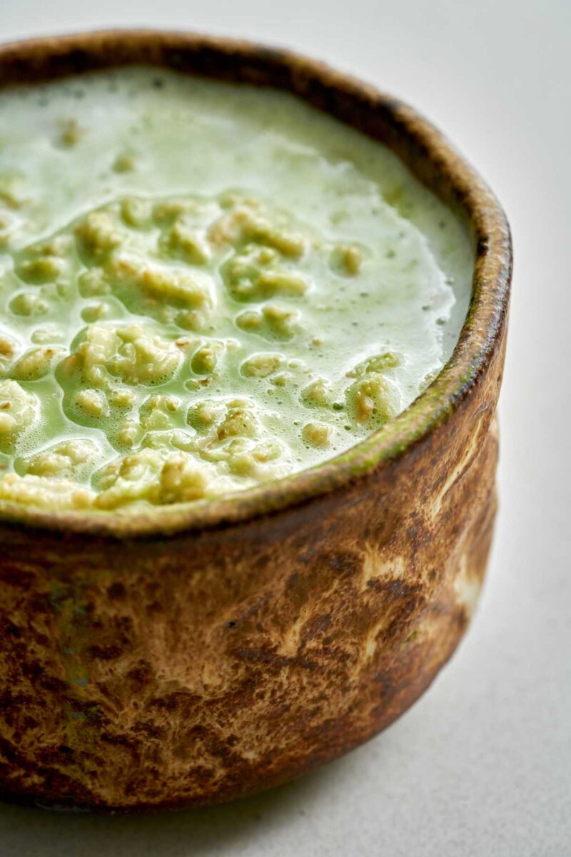 Green runny oatmeal in a matcha bowl.