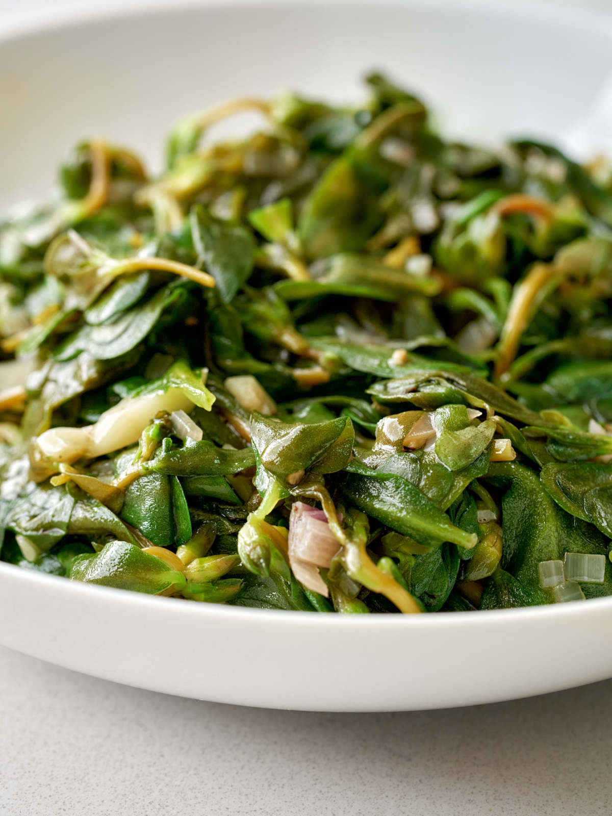 Sauteed greens in a white serving dish.