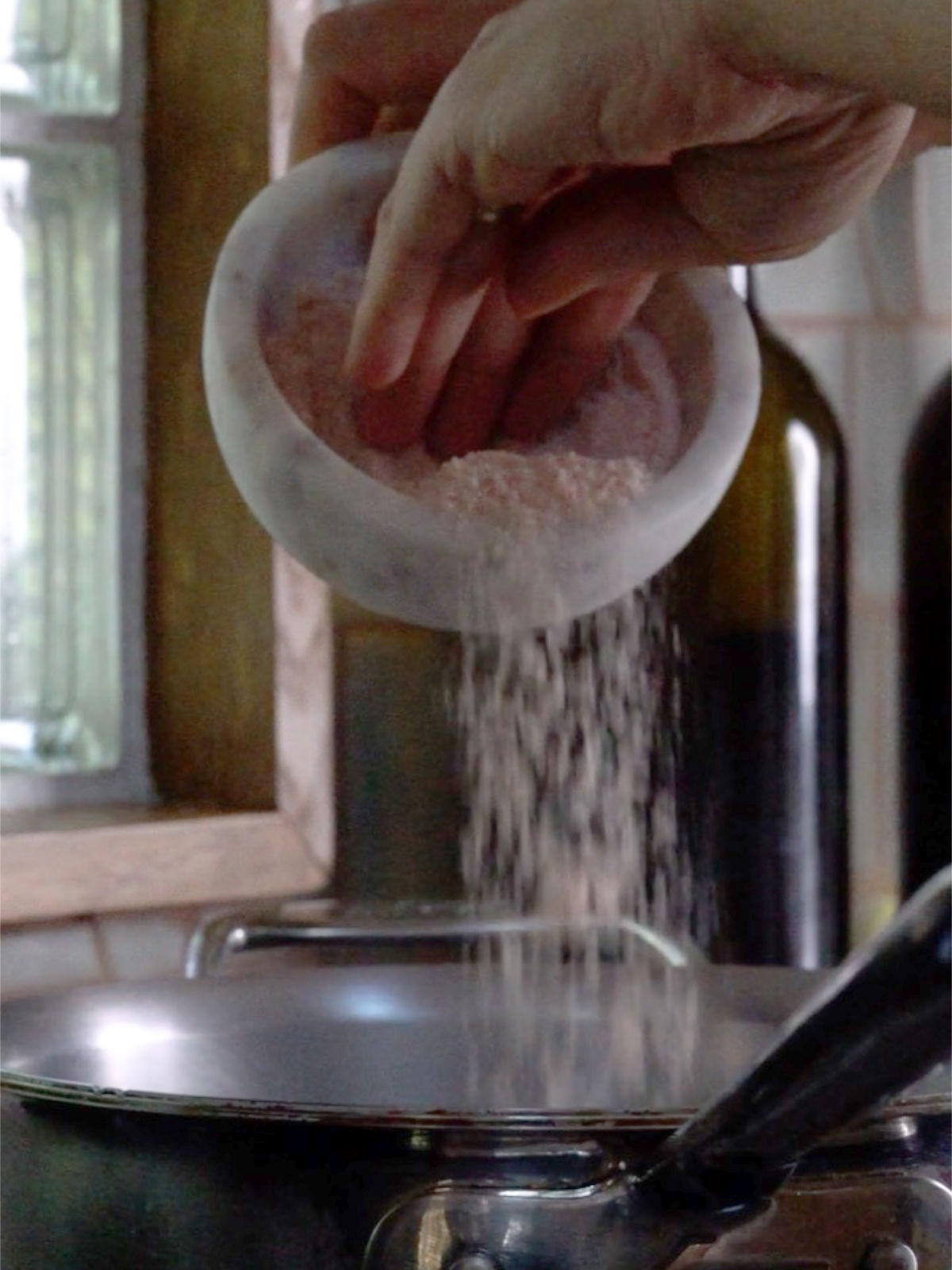 Pouring pink salt into a metal pot.