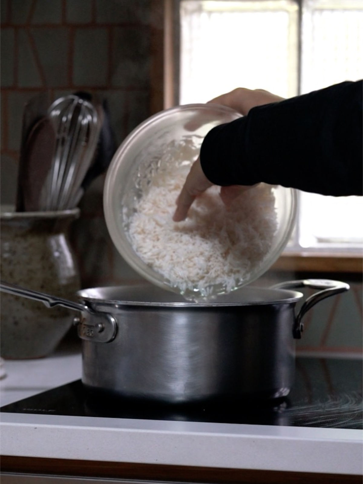 Pouring rice into a metal pot.