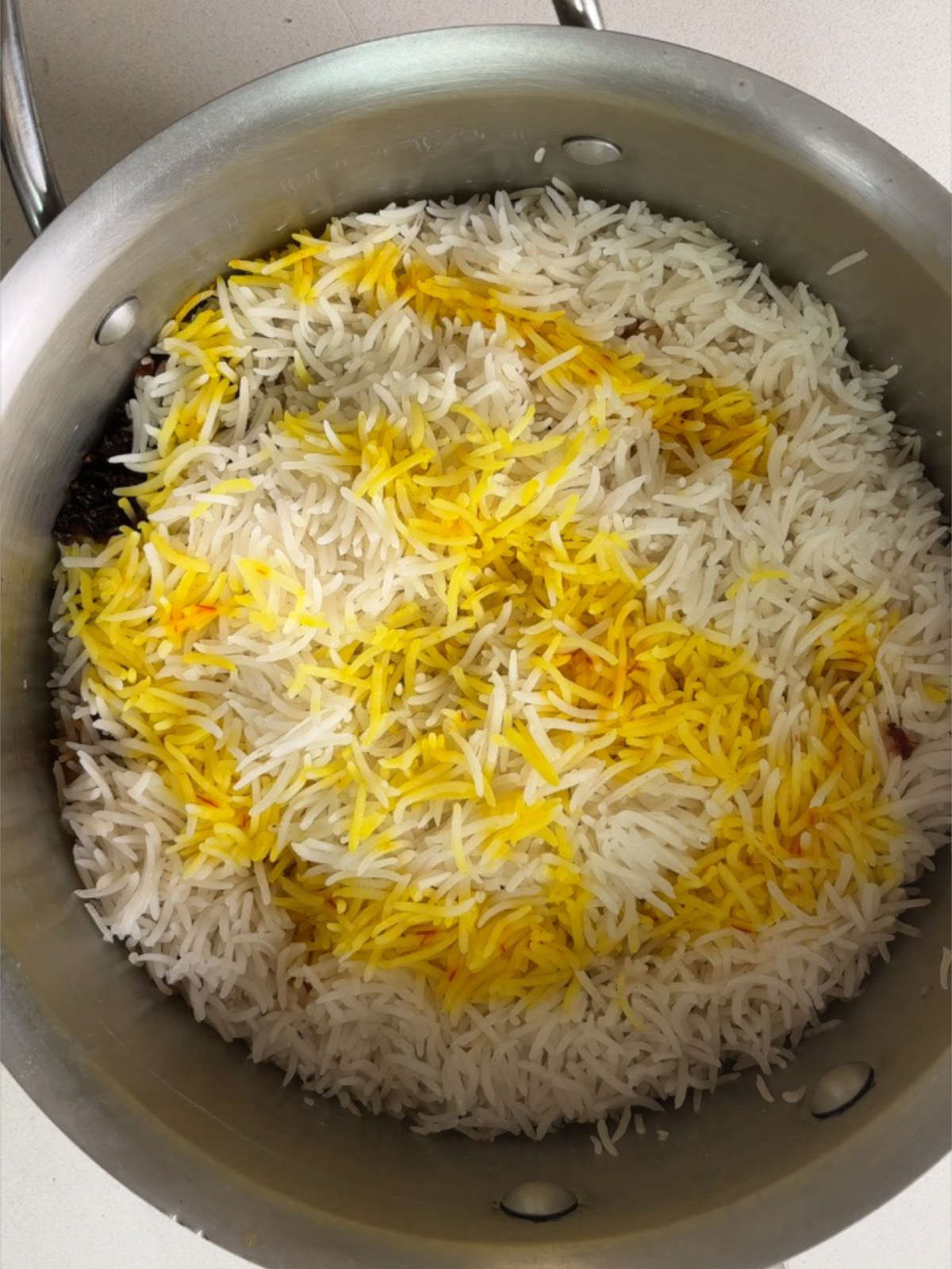 Rice in a pot with some saffron making it both yellow and white.