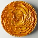 Persimmon arranged in a rose pattern in a round tart pan.