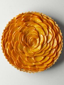 Persimmon arranged in a rose pattern in a round tart pan.