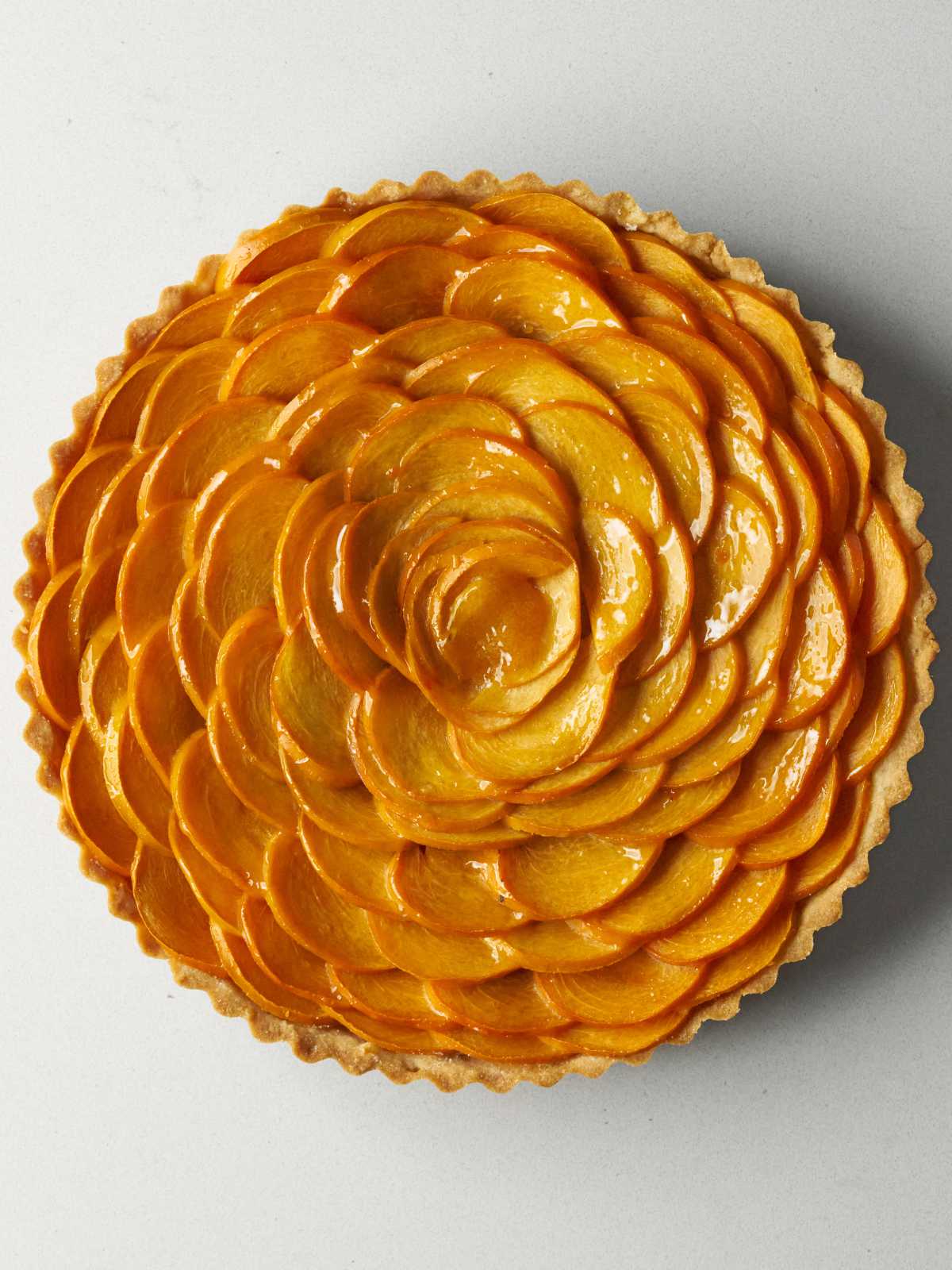 Persimmon arranged in a rose pattern with a dollop of orange jam in the center.