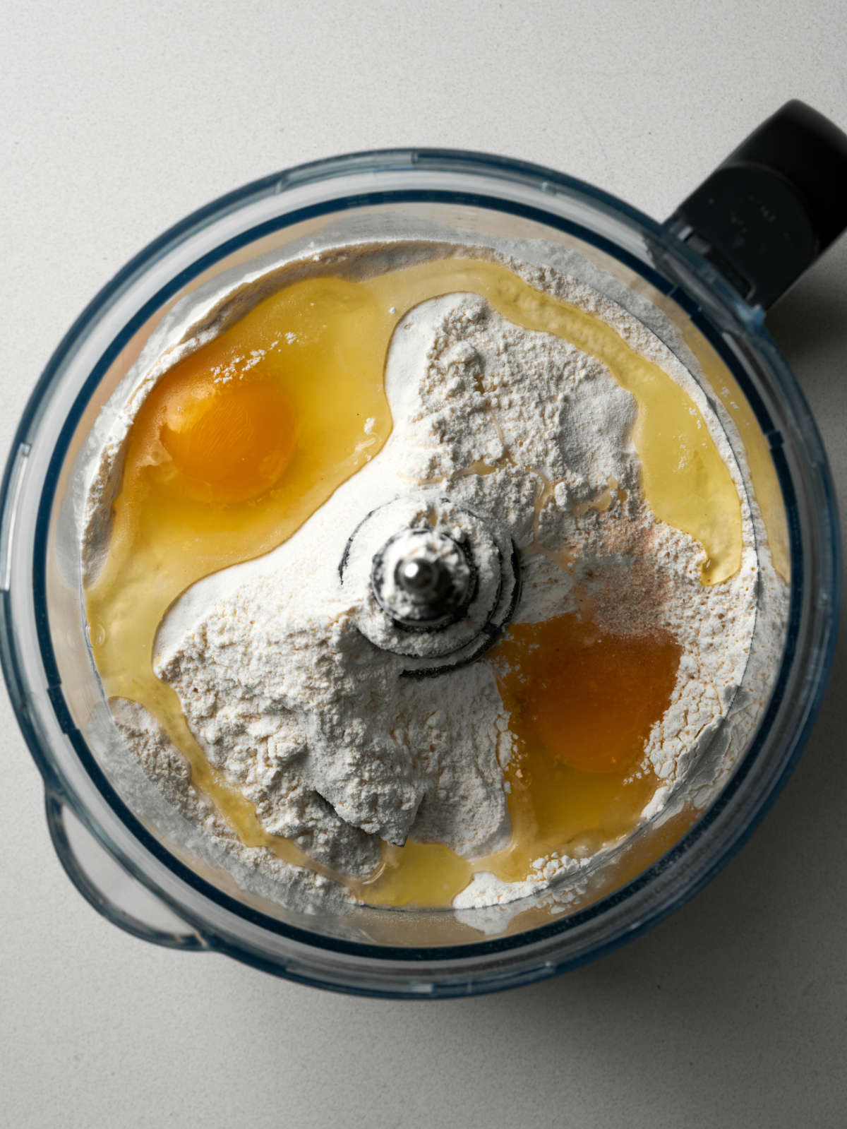 Flour and eggs in a food processor bowl.