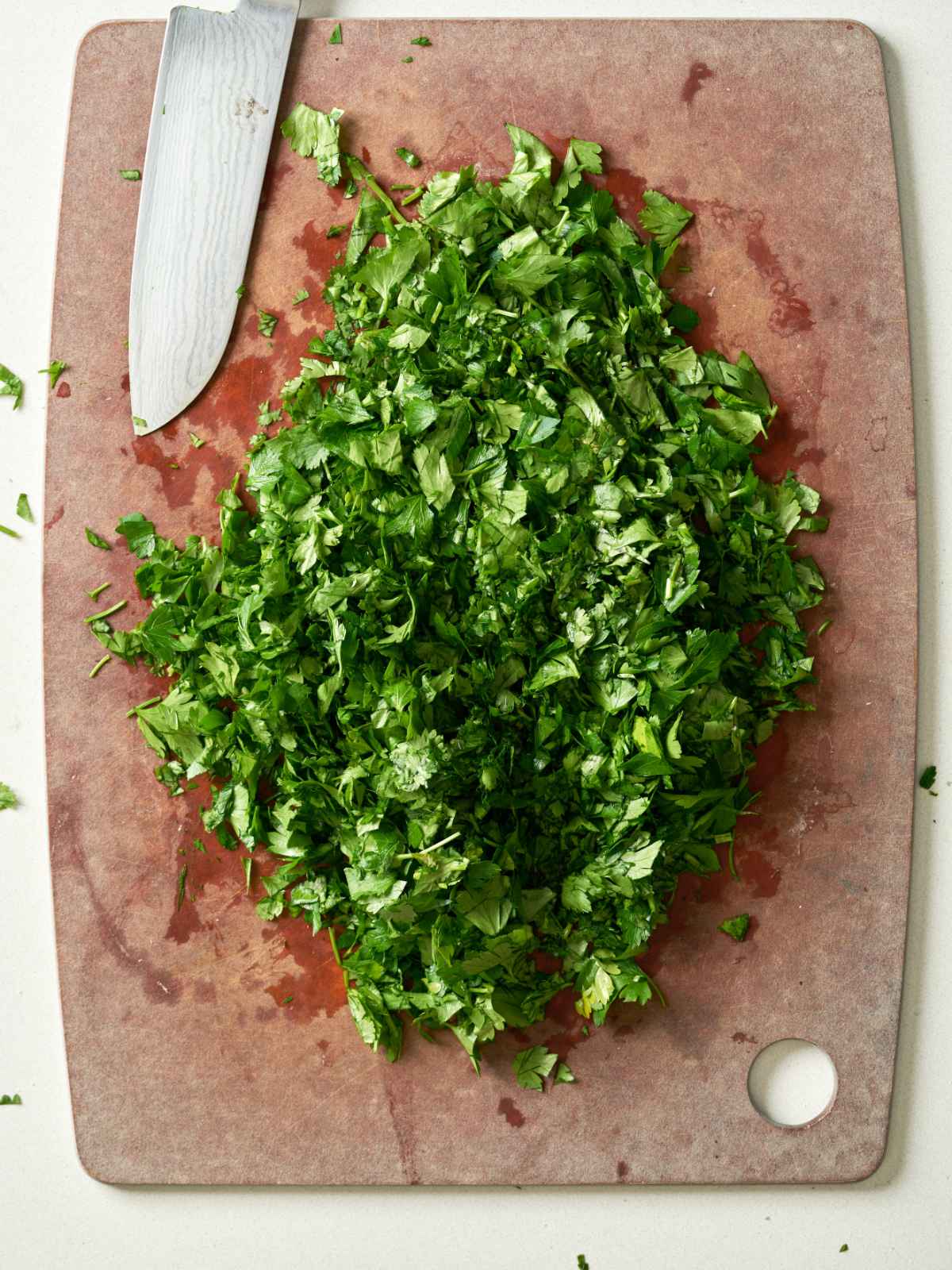 Pile of chopped fresh herbs on a chopping board