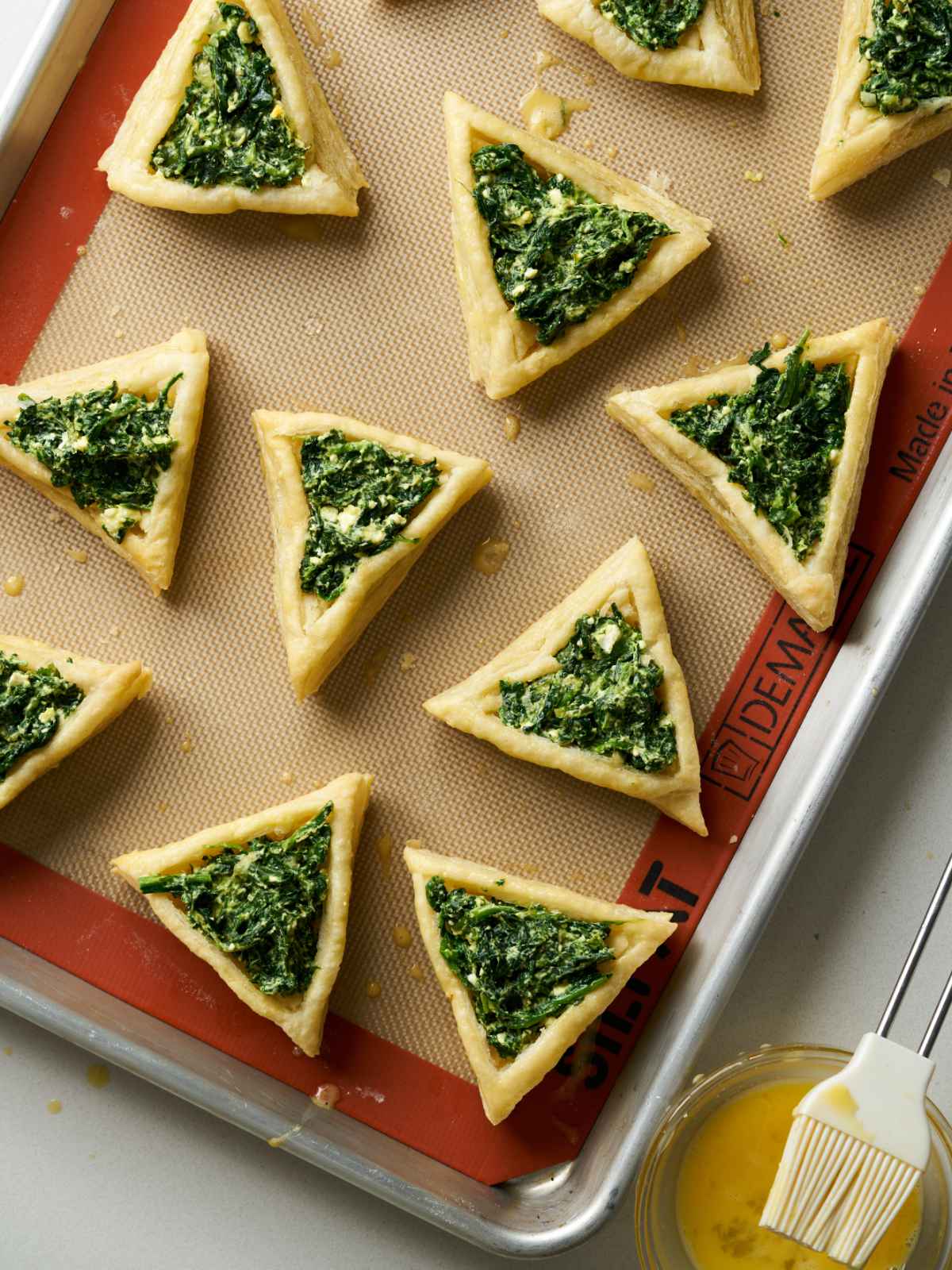 Triangles of puff pasty with a green herb filling in the middle