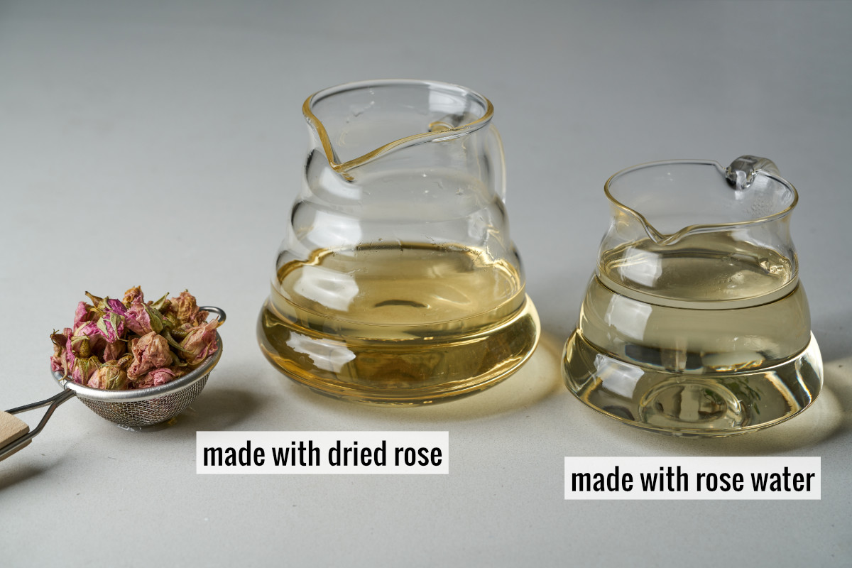 A strainer with dried rose petals next to two glass pitchers filled with yellow liquid, one less yellow than the other.