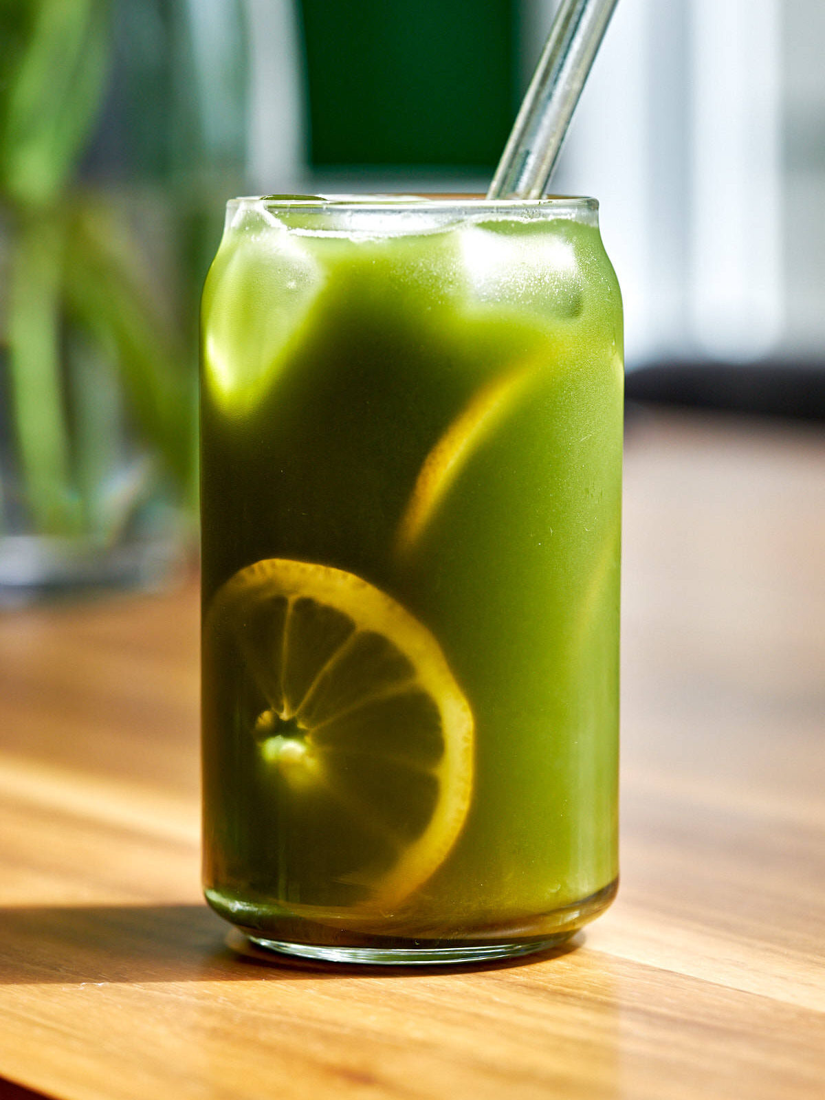 Glass of iced green tea with lemon slices.