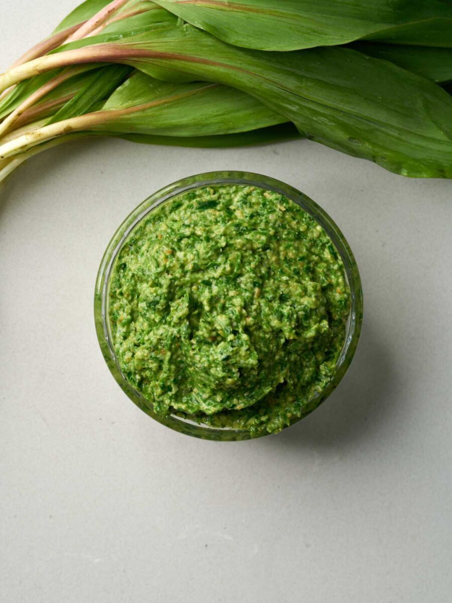 Top down view of a jar of vibrant green pesto