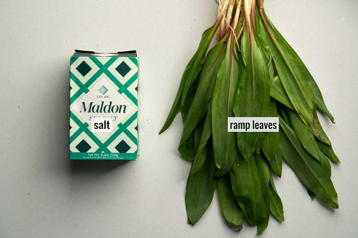 A box of Maldon salt next to ramp leaves.