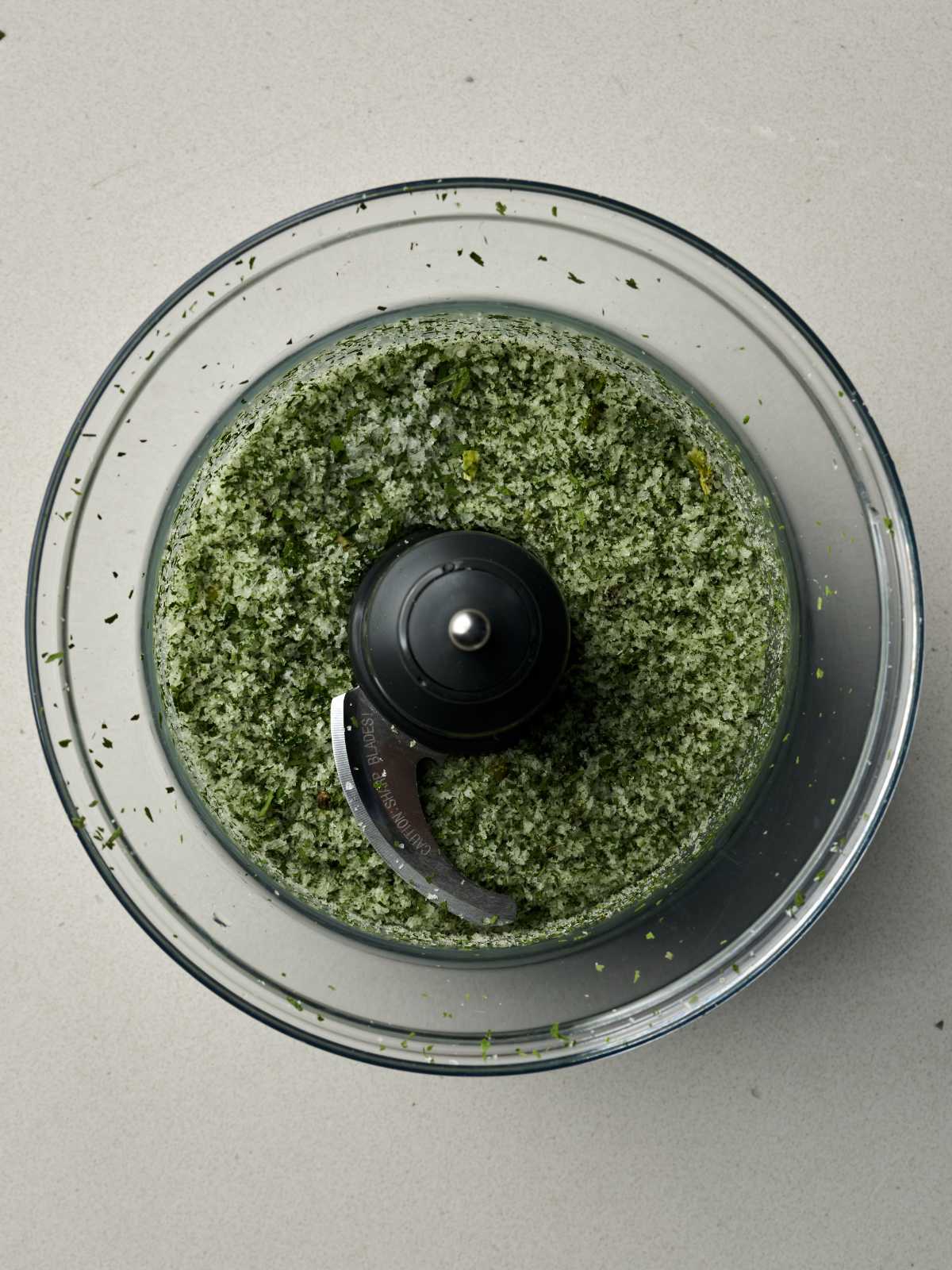 Green and white salt blending in a food processor