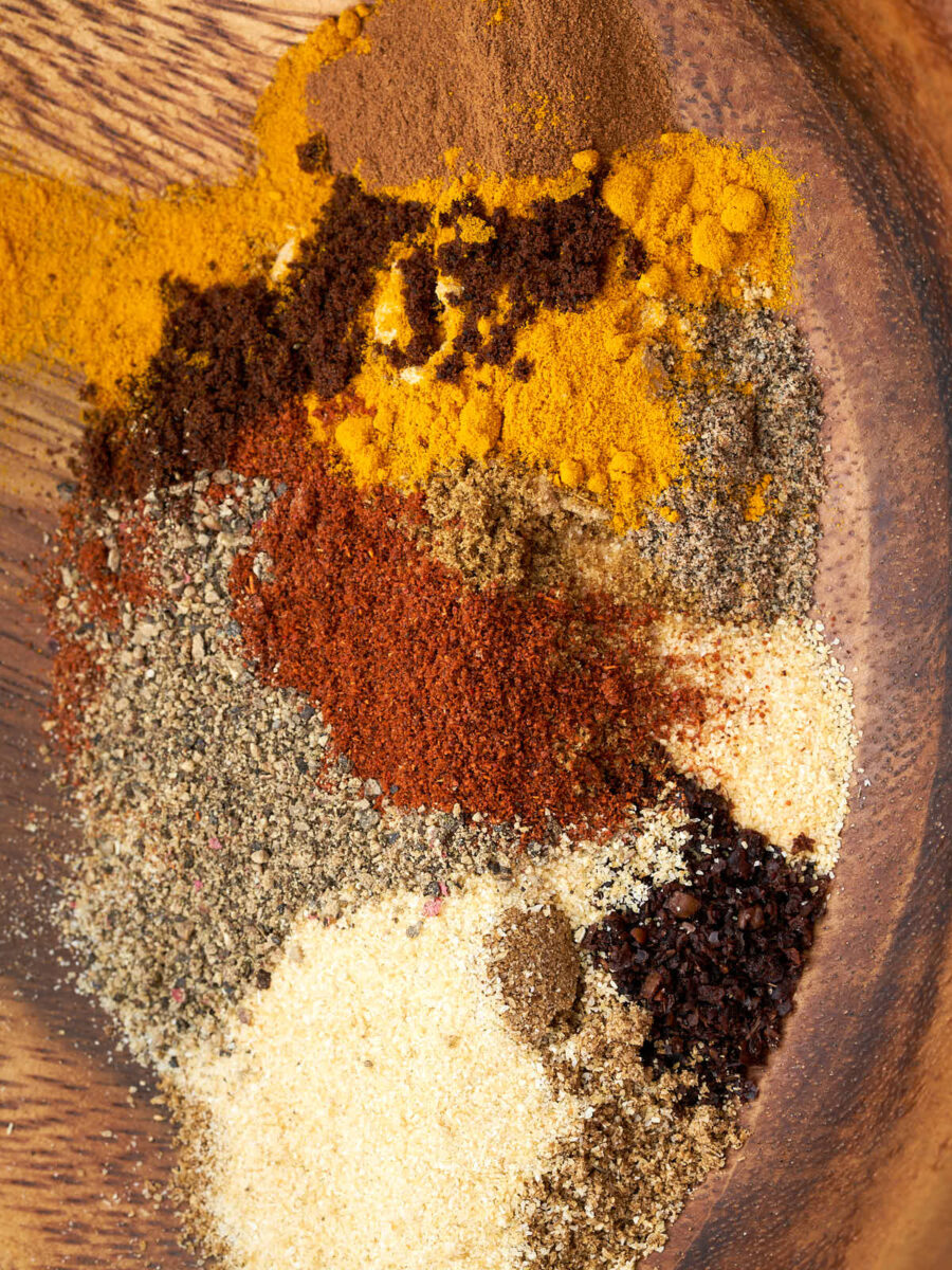 Colorful spices in a wooden bowl.