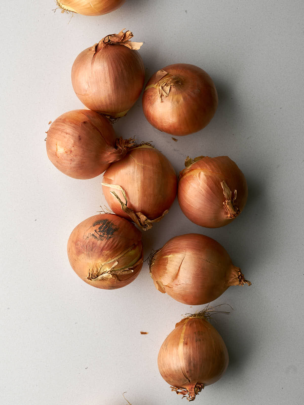 Yellow onions in a cluster on a countertop.