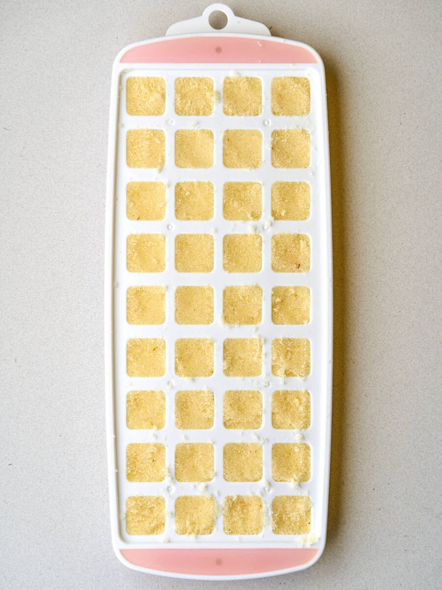 Yellow sugar cubes in a white and pink mold.