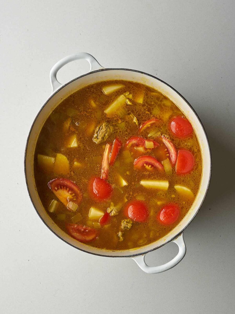 The stew cooking further, with a richer, more orange-red color.