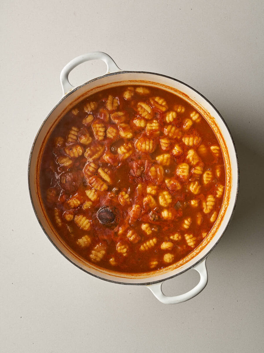 Ridged potato gnocchi added to the simmering red stew.